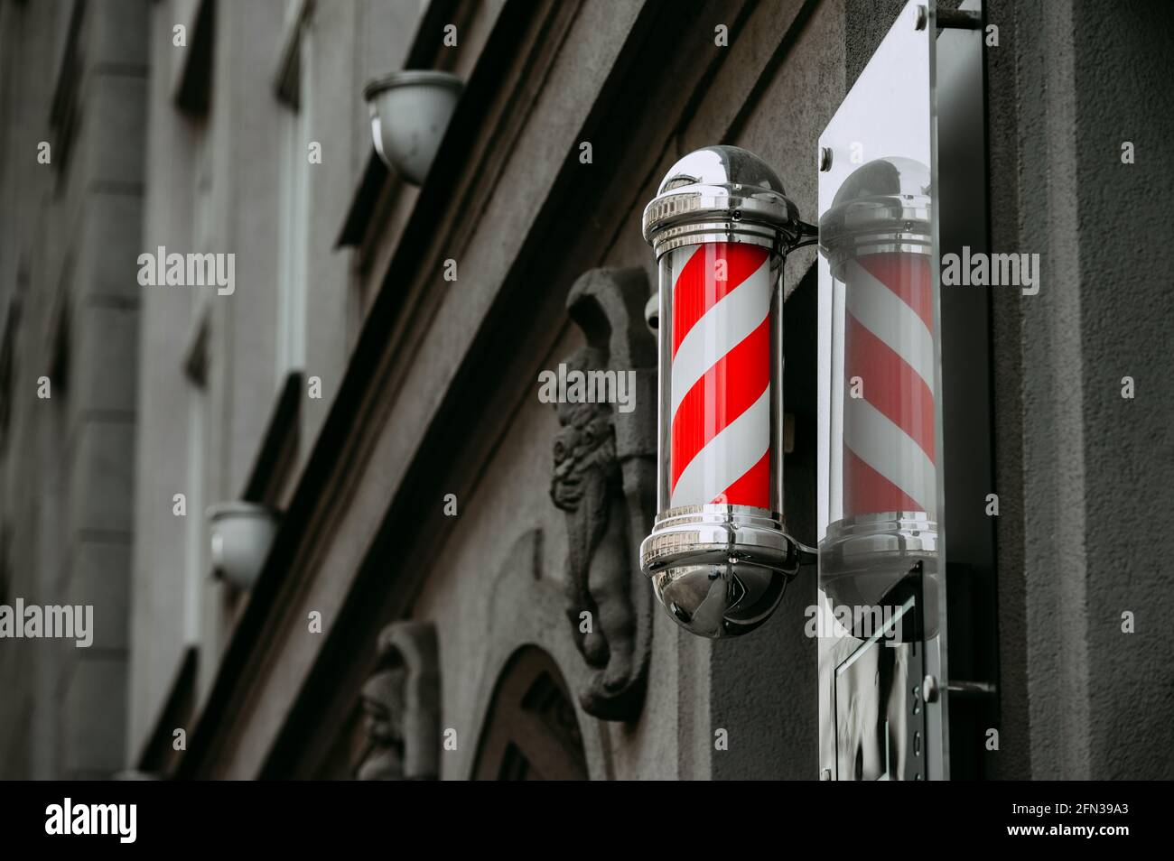 Barbiere segno rosso e bianco sullo sfondo della città Foto Stock