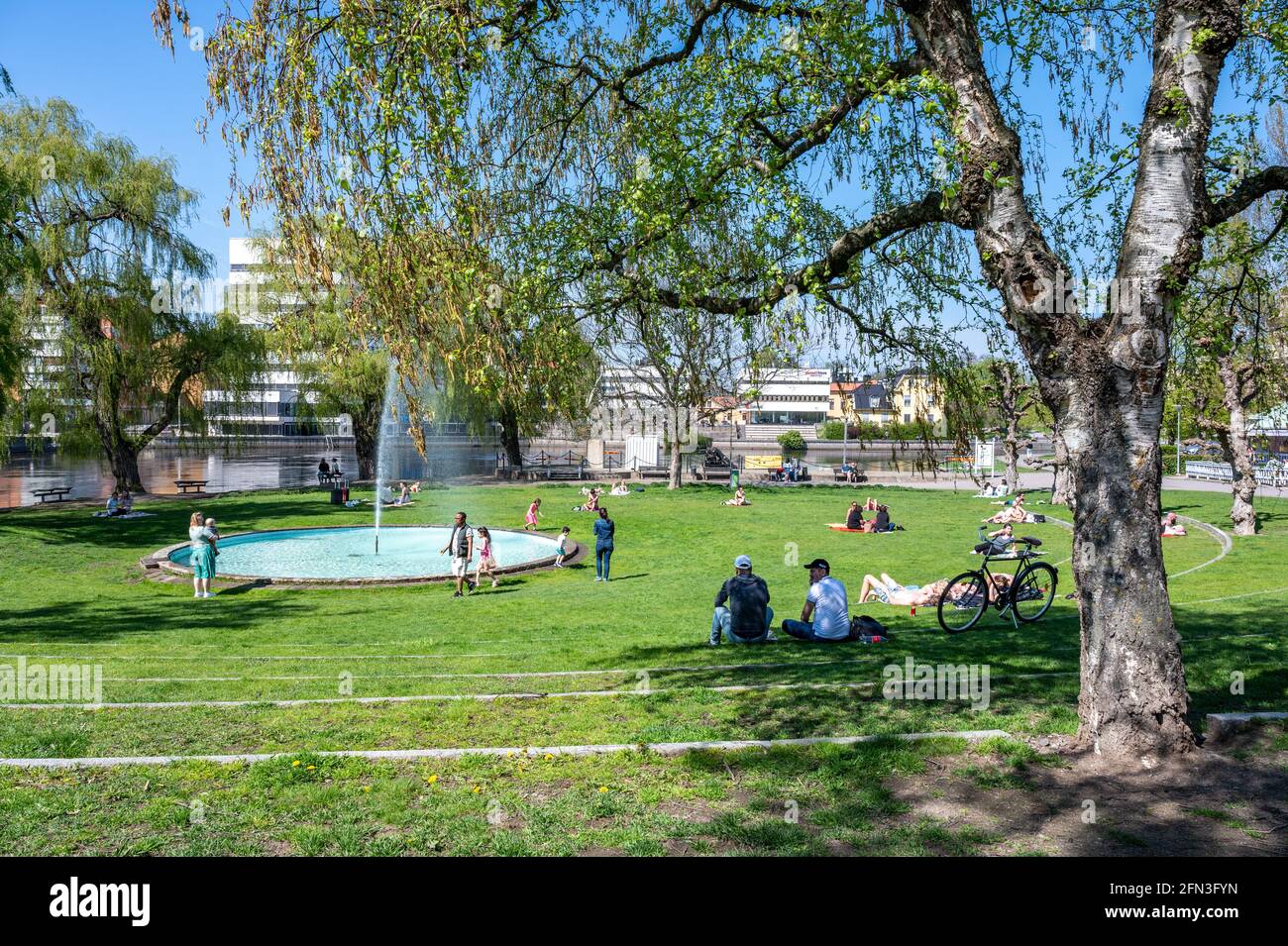 La gente gode di una soleggiata giornata primaverile nel parco cittadino di Strömparken, Norrköping in Svezia Foto Stock