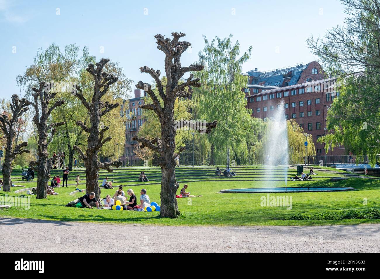 La gente gode di una soleggiata giornata primaverile nel parco cittadino di Strömparken, Norrköping in Svezia Foto Stock