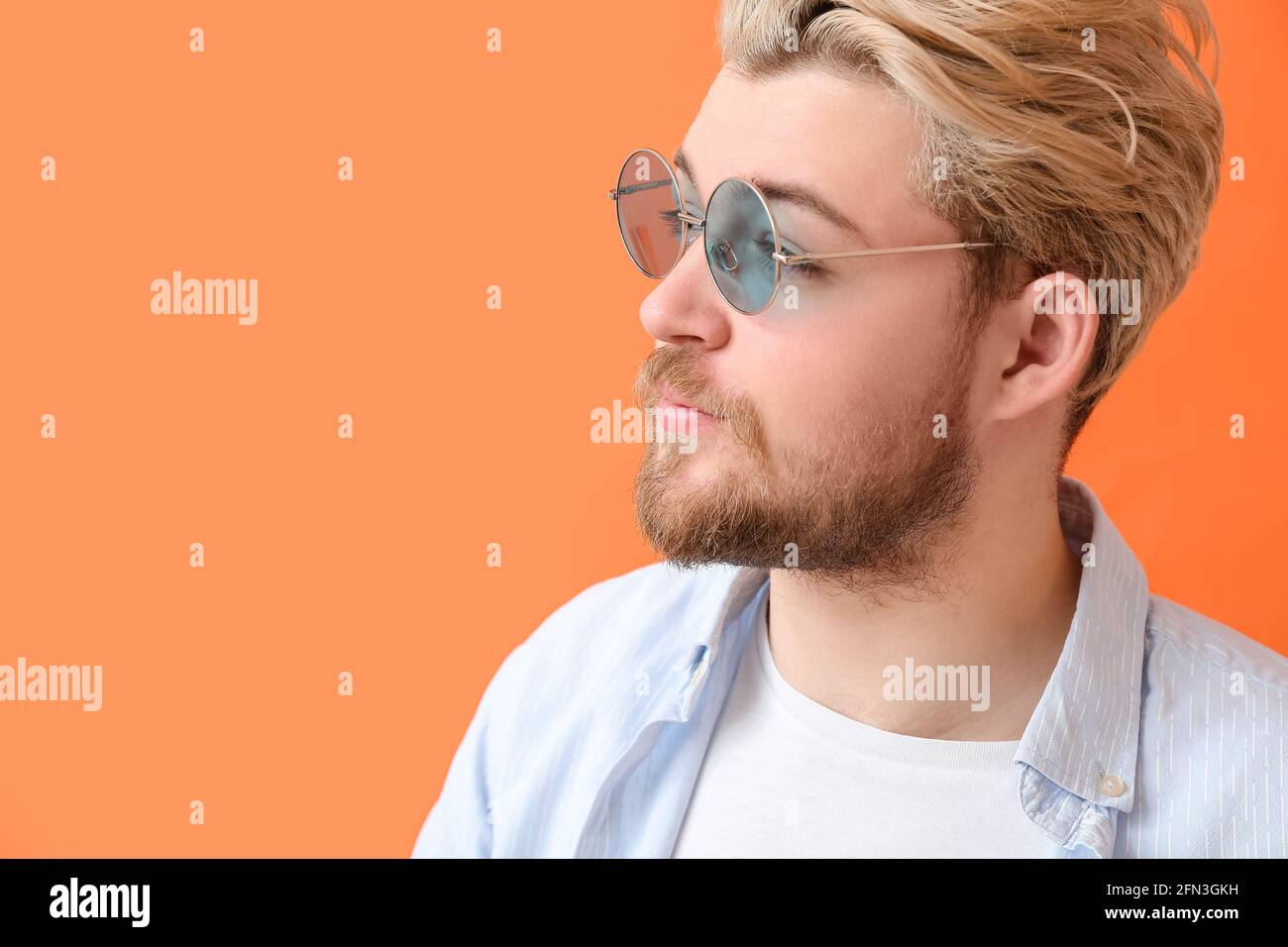 Giovane uomo con eleganti occhiali da sole su sfondo colorato Foto stock -  Alamy