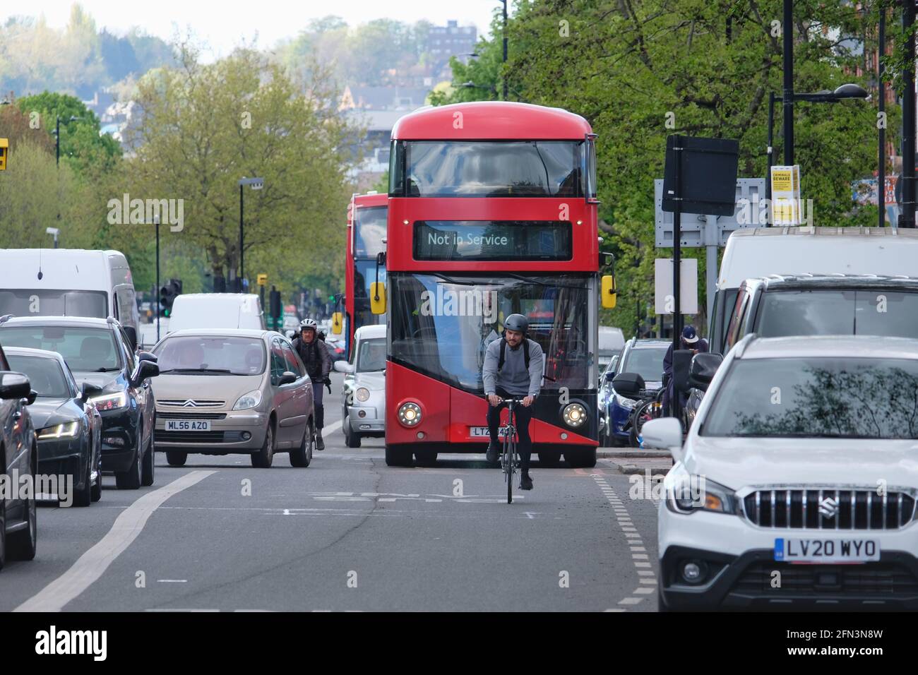 Un ciclista si muove con facilità nella corsia condivisa di ciclotono, motociclette e autobus mentre il traffico di altri veicoli si ferma a Holloway Road, a nord di Londra. Foto Stock