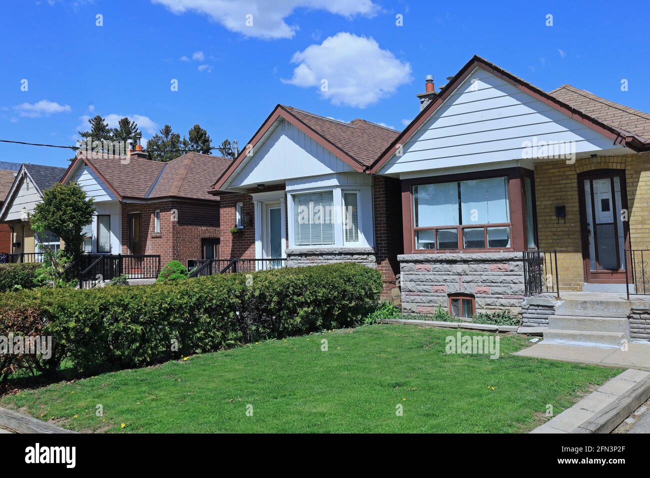 Fila di piccole case bungalow in mattoni con gables Foto Stock