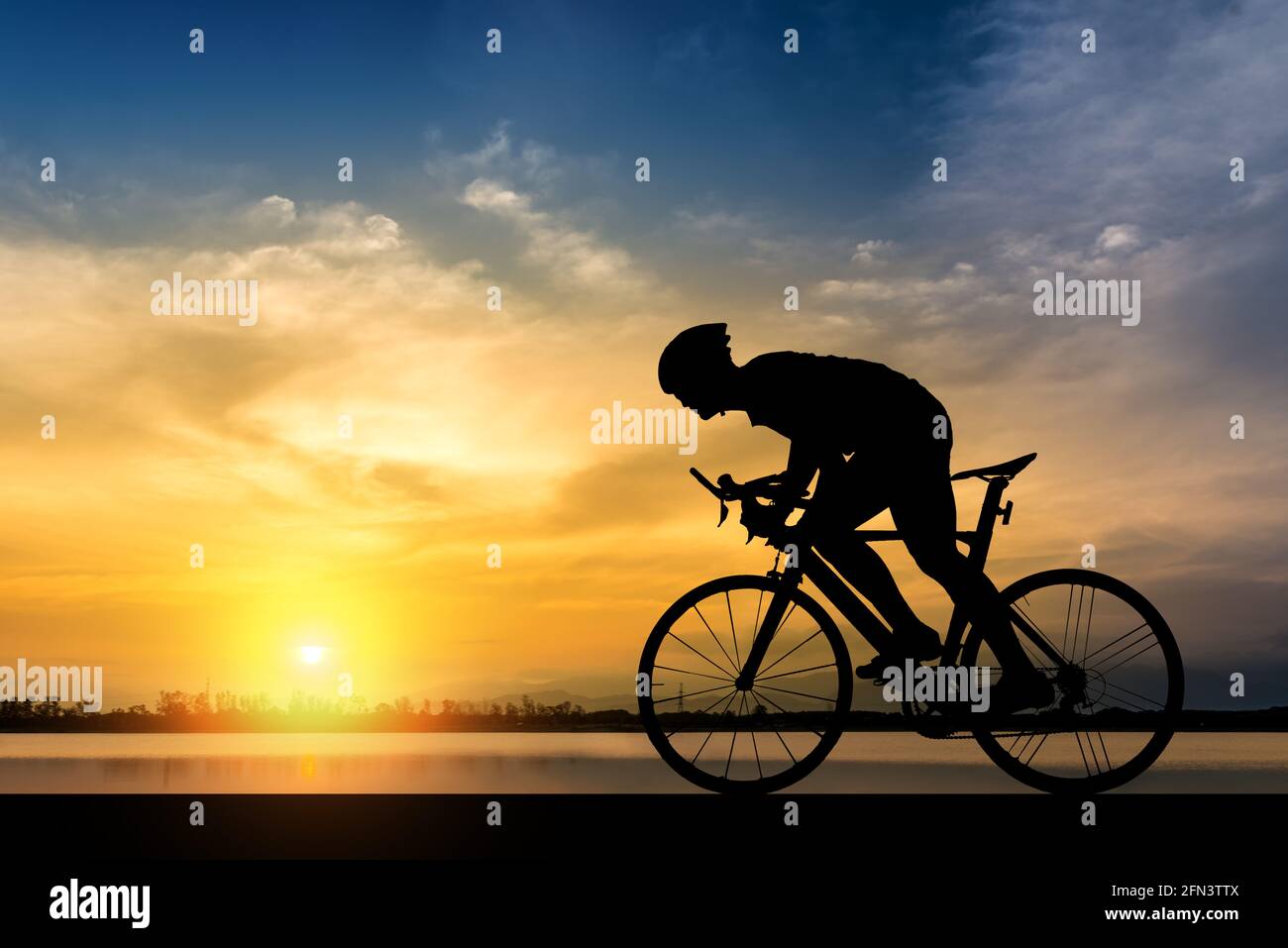 Silhouette di un ciclista sullo sfondo dello splendido tramonto,Silhouette dell'uomo un giro in bicicletta in background al tramonto. Foto Stock