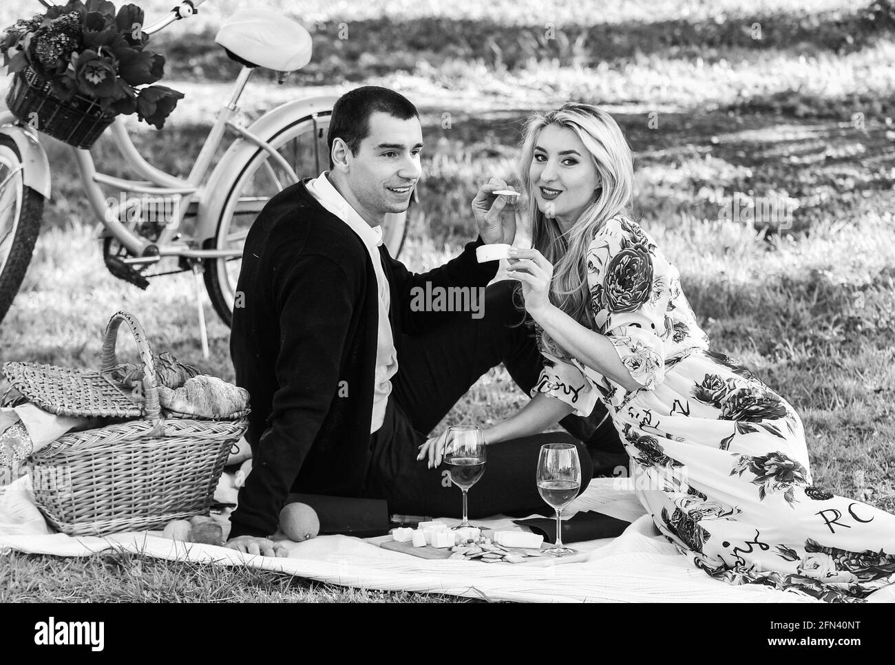 Dare spontaneamente doni non comuni e unici. Godendo la loro data perfetta. Coppia in amore pic-nic data. Weekend di primavera. Felice coppia amorevole in cui rilassarsi Foto Stock