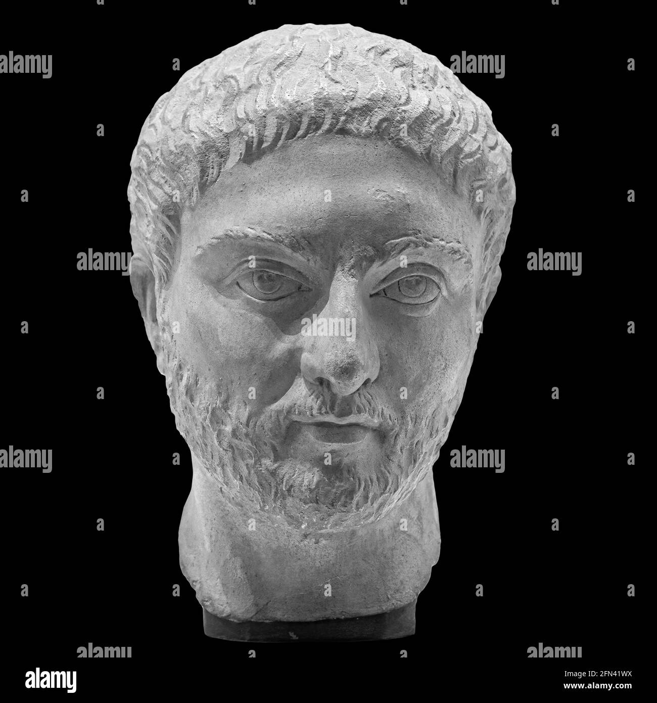 Copia in gesso dell'antica statua dell'uomo con la testa della barba isolata su sfondo nero. Intonaco scultura uomo faccia Foto Stock