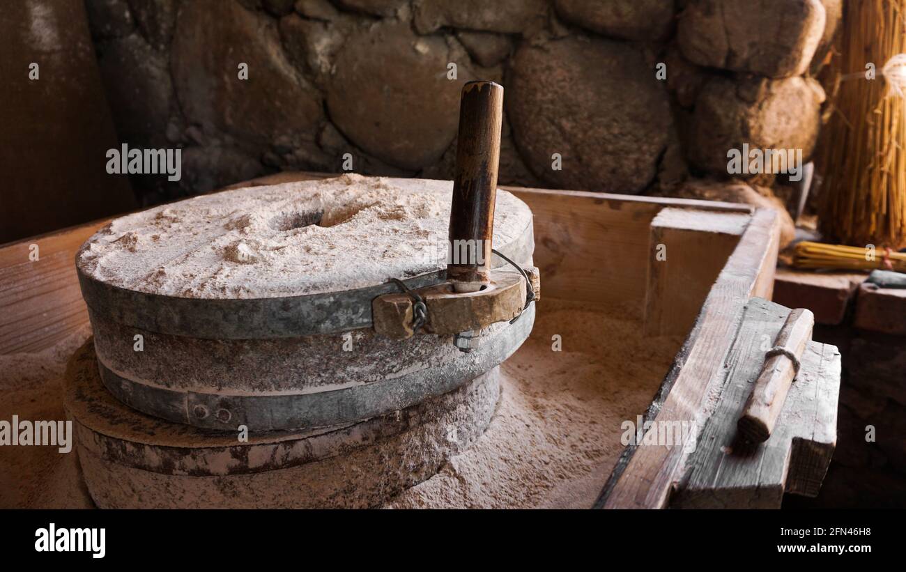 Un antico mulino a mano fatto di pietre e legno. Dispositivo di macinazione della farina. Artigianato autentico Foto Stock