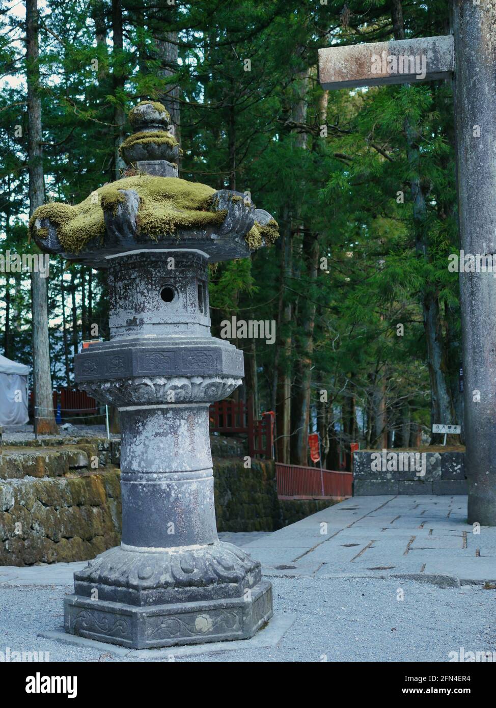 Lanterne giapponesi in pietra allineate. Antiche lanterne in pietra con muschio verde in cima. Tradizione giapponese e stile barocco. Foto Stock