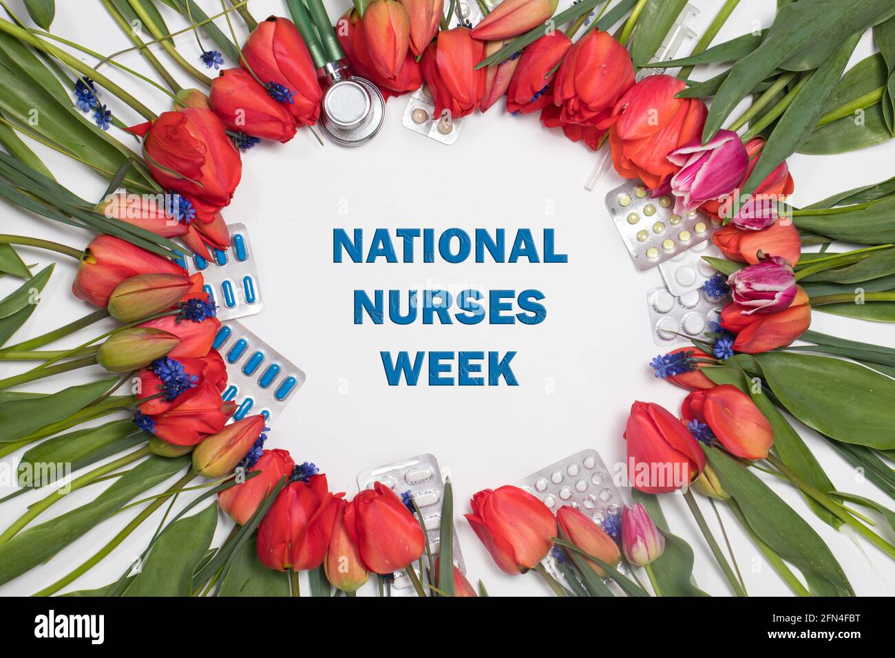 Fiori, fonendoscopio e compresse - un banner con iscrizione Happy Nurse's Week su bianco Foto Stock