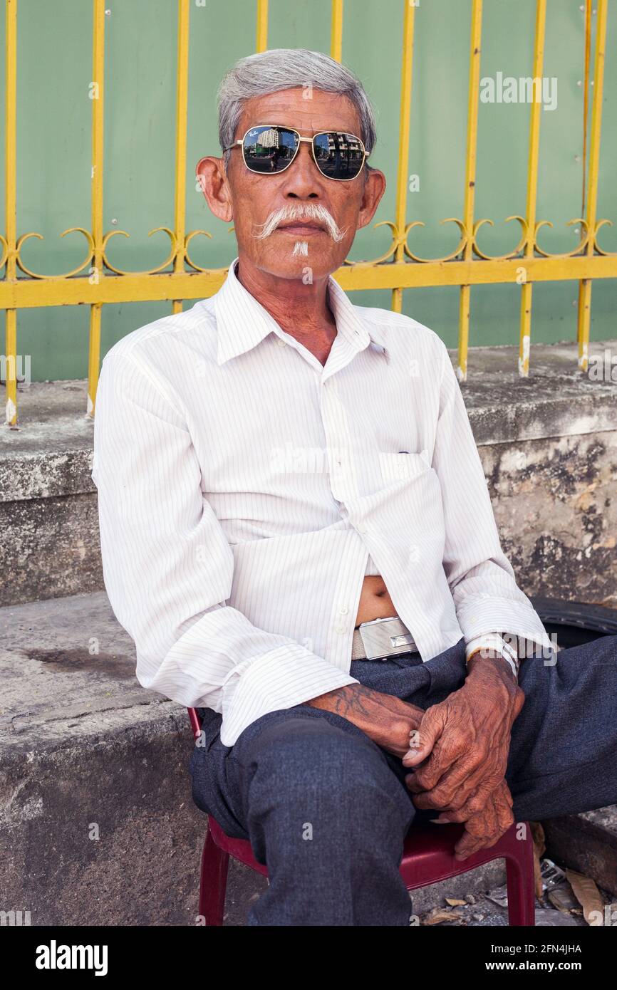 Primo piano ritratto di intimidire anziani vietnamiti con tatuaggi e una storia da raccontare, da Nang, Vietnam Foto Stock