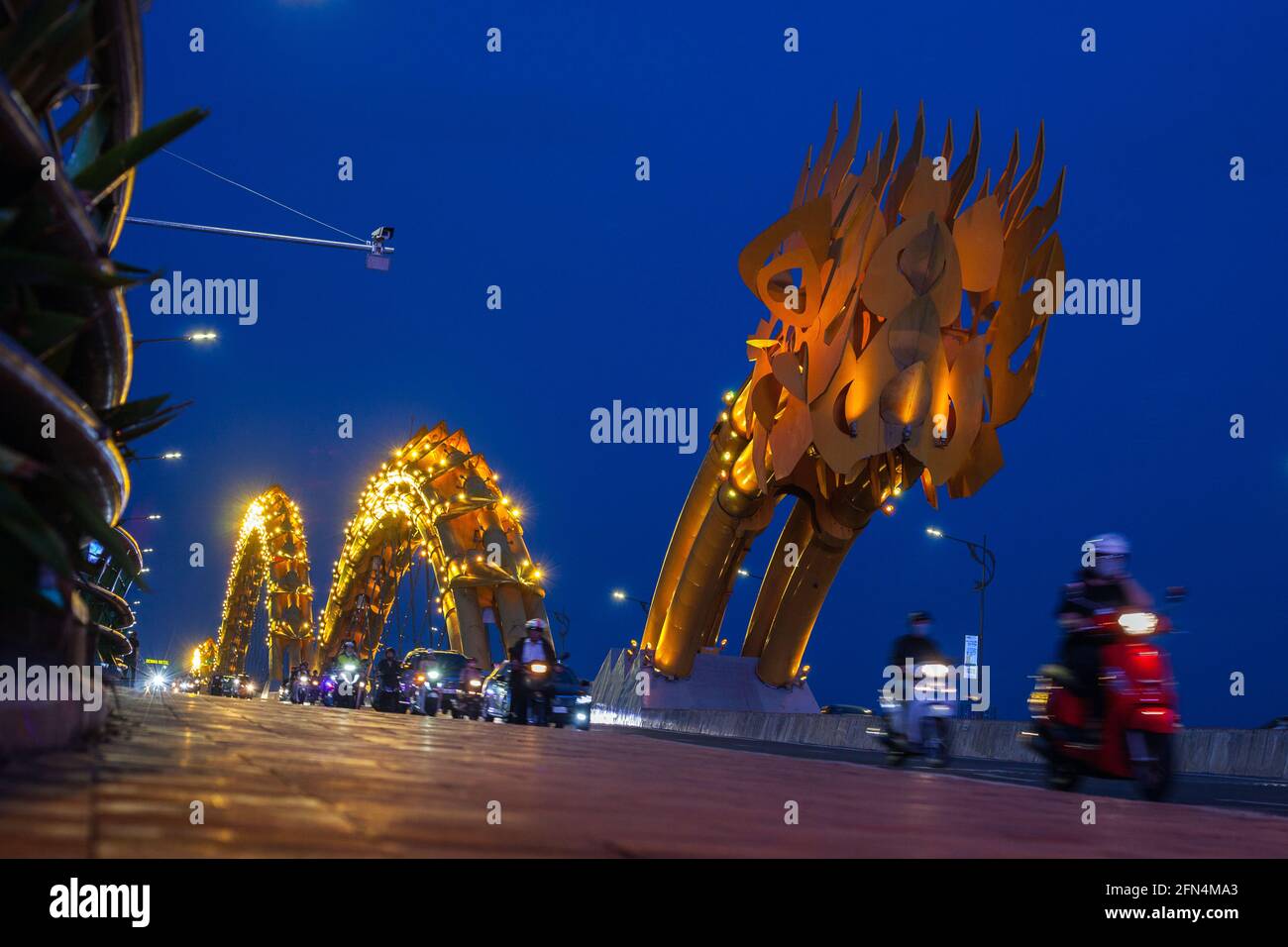 Dragon Bridge si è illuminato con luci al neon gialle al tramonto, da Nang, Vietnam Foto Stock