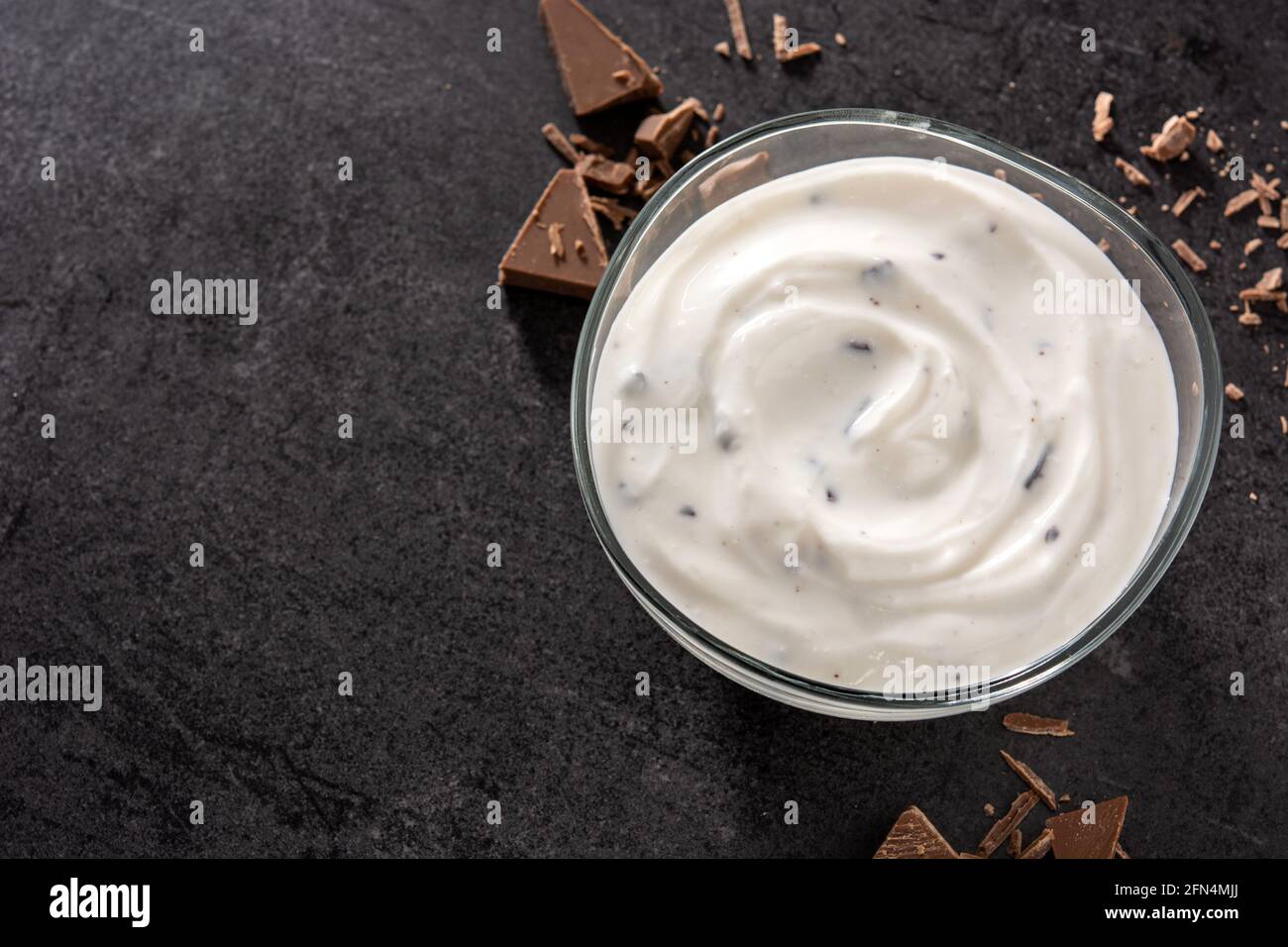 Stracciatella yogurt in recipiente trasparente su fondo nero Foto Stock