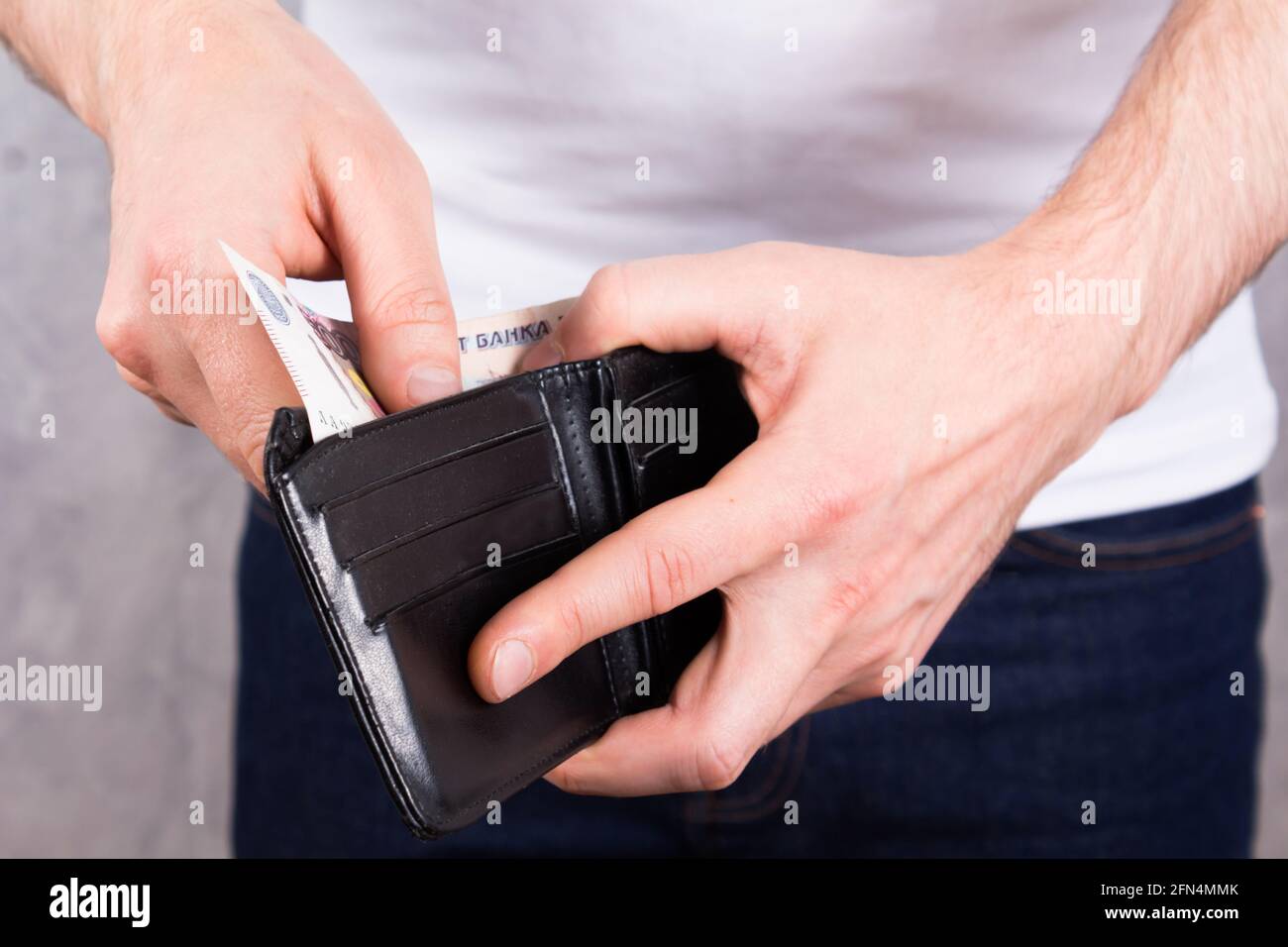 Irriconoscibile giovane caucasico con portafoglio in pelle nera con 500 rubli russi in mano. Primo piano della foto. Concetto di crisi finanziaria. Foto Stock