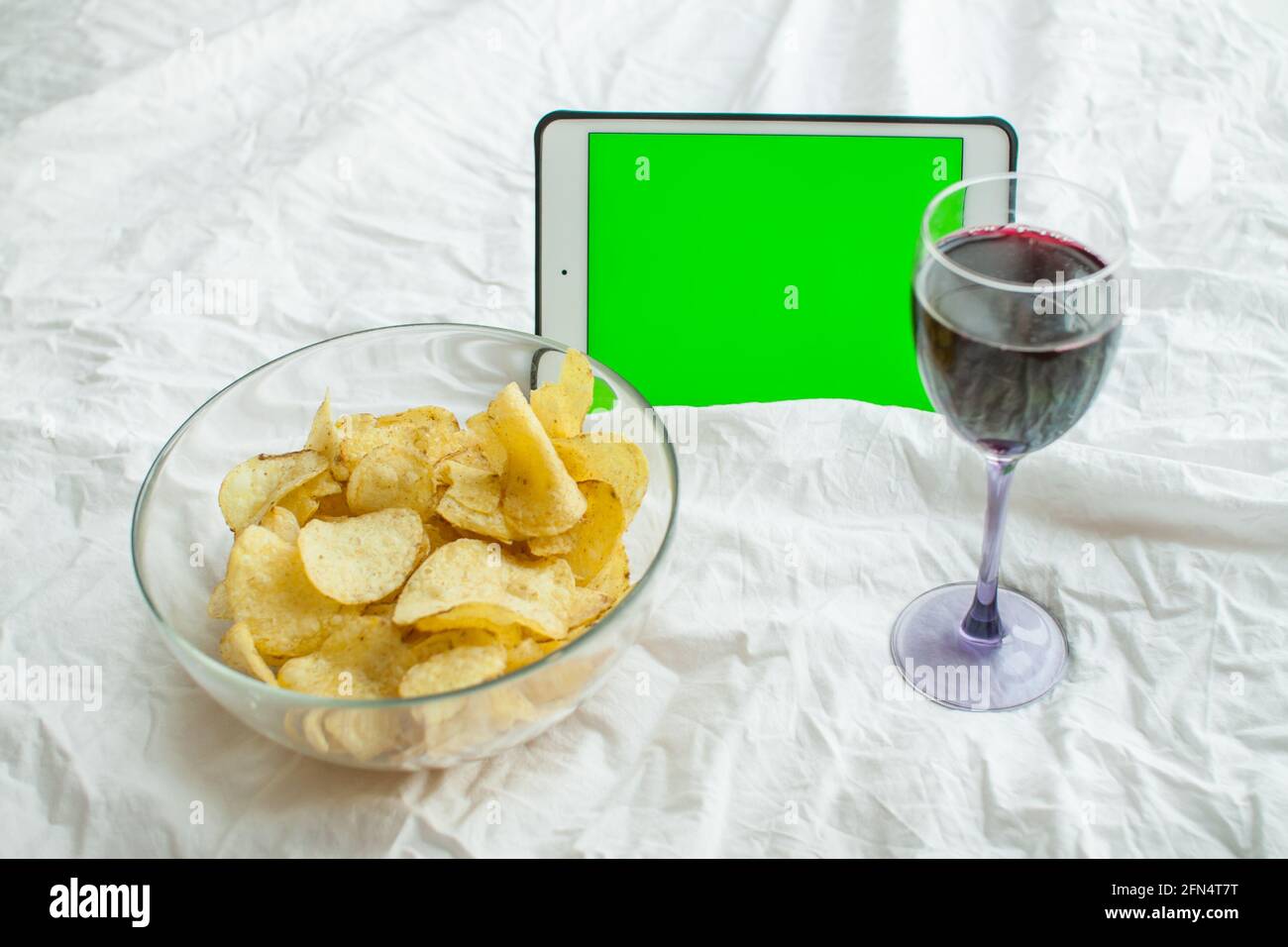 Un weekend solitario con un film, patatine e vino. Alleviare lo stress. Cibo spazzatura. Pasto a base di formaggio Foto Stock