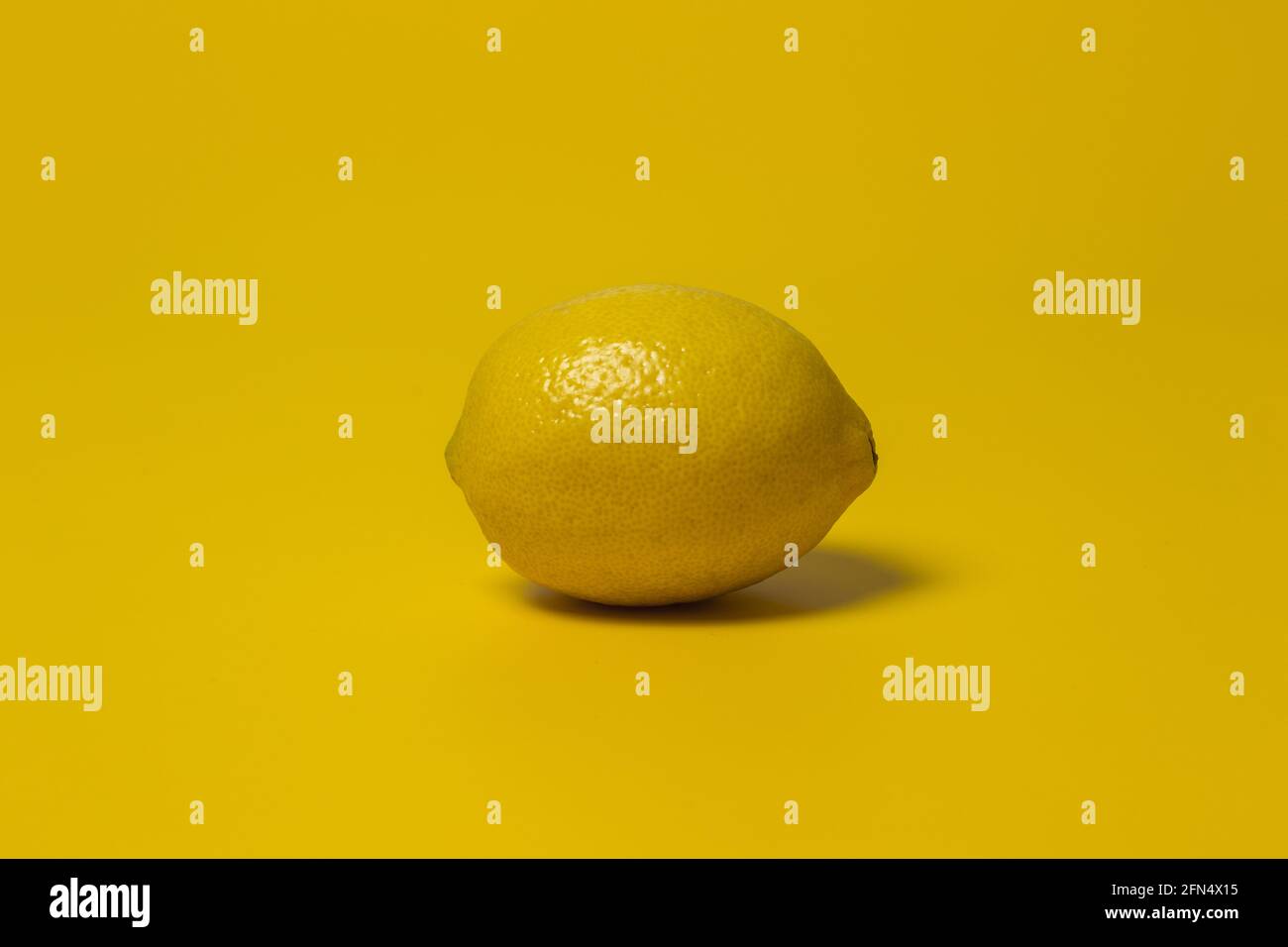 un limone giallo su sfondo giallo Foto Stock