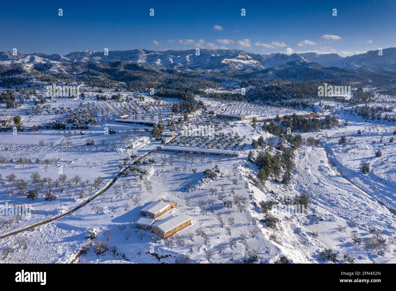 Vista aerea del villaggio di Arnes in un pomeriggio innevato invernale dopo una forte nevicata (Terra alta, Tarragona, Catalogna, Spagna) ESP: Vista aérea de Arnes Foto Stock