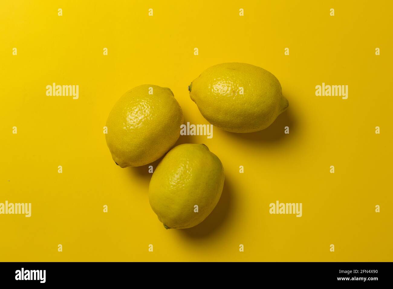 limoni gialli su sfondo giallo Foto Stock