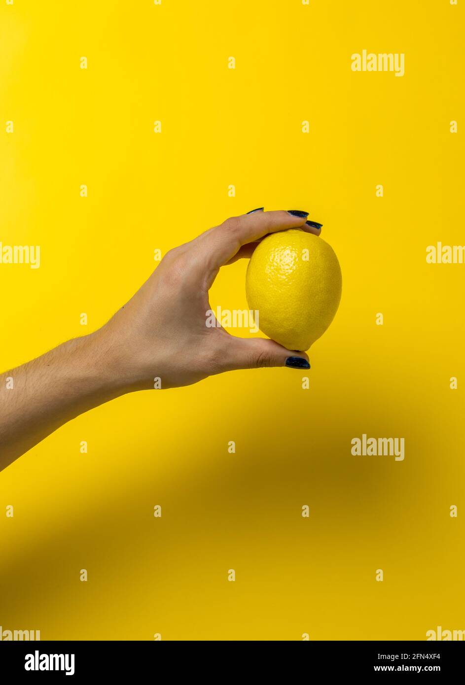 mano che tiene un limone Foto Stock