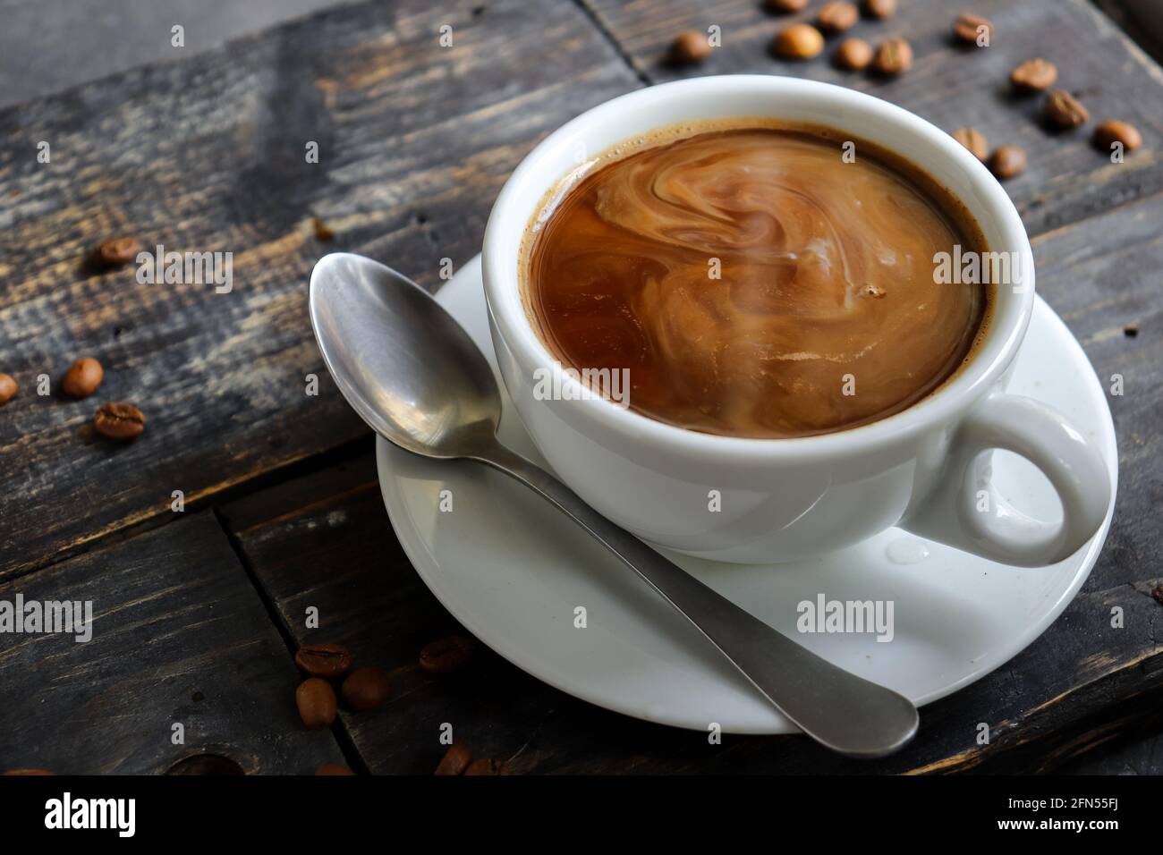 Tazza di caffè e chicchi di caffè. Spazio di copia. Espresso o Americano in una tazza. Sfondo di legno. Foto Stock