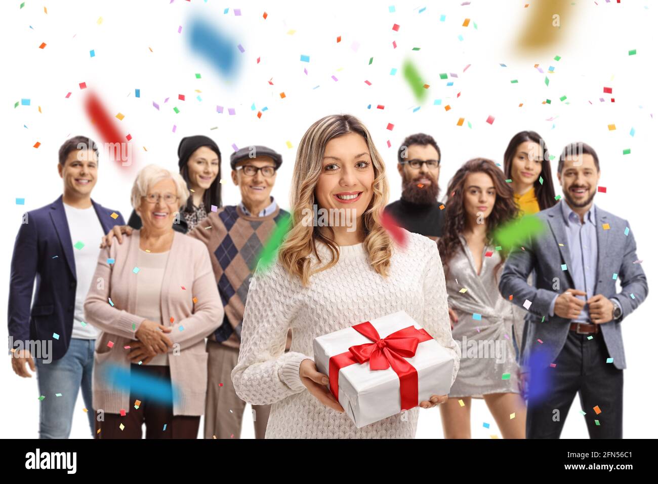 Donna che tiene un regalo ad una celebrazione con gli amici e. famiglia e confetti intorno isolato su sfondo bianco Foto Stock