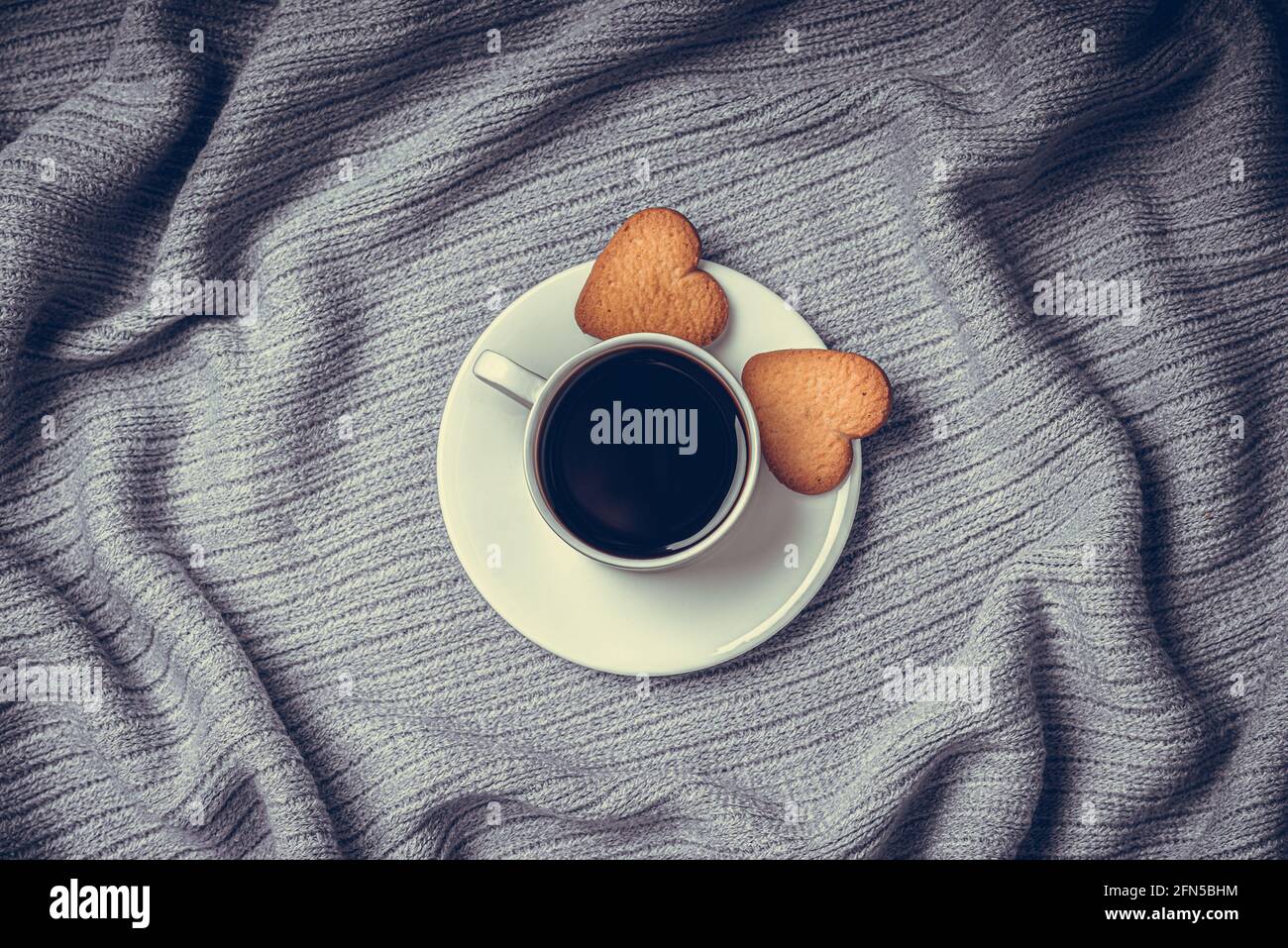 Una tazza di caffè su un tavolo coperto da una coperta. Foto Stock