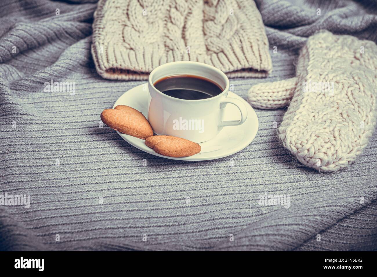 Una tazza di caffè su un tavolo coperto da una coperta. Foto Stock