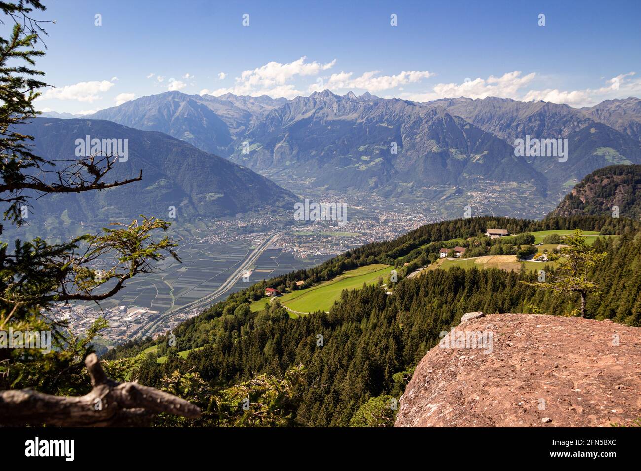 Vista panoramica ad alto angolo sulla città di Merano e la catena montuosa di Texelgruppe vista dall'iconico punto panoramico 'Knottnkino' a Vöran, Alto Adige, Italia Foto Stock