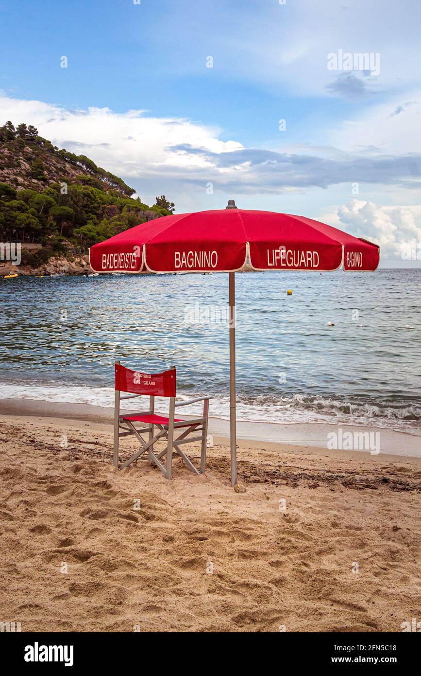 Bagnino sedia e ombrellone alla spiaggia vuota di Fetovaia, Isola d'Elba,  Toscana, Italia; concetto di soccorso e sicurezza per i bagnanti Foto stock  - Alamy