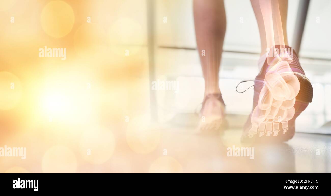 Composizione di macchie di luce sulla donna che corre sul tapis roulant con le ossa del piede che mostrano Foto Stock