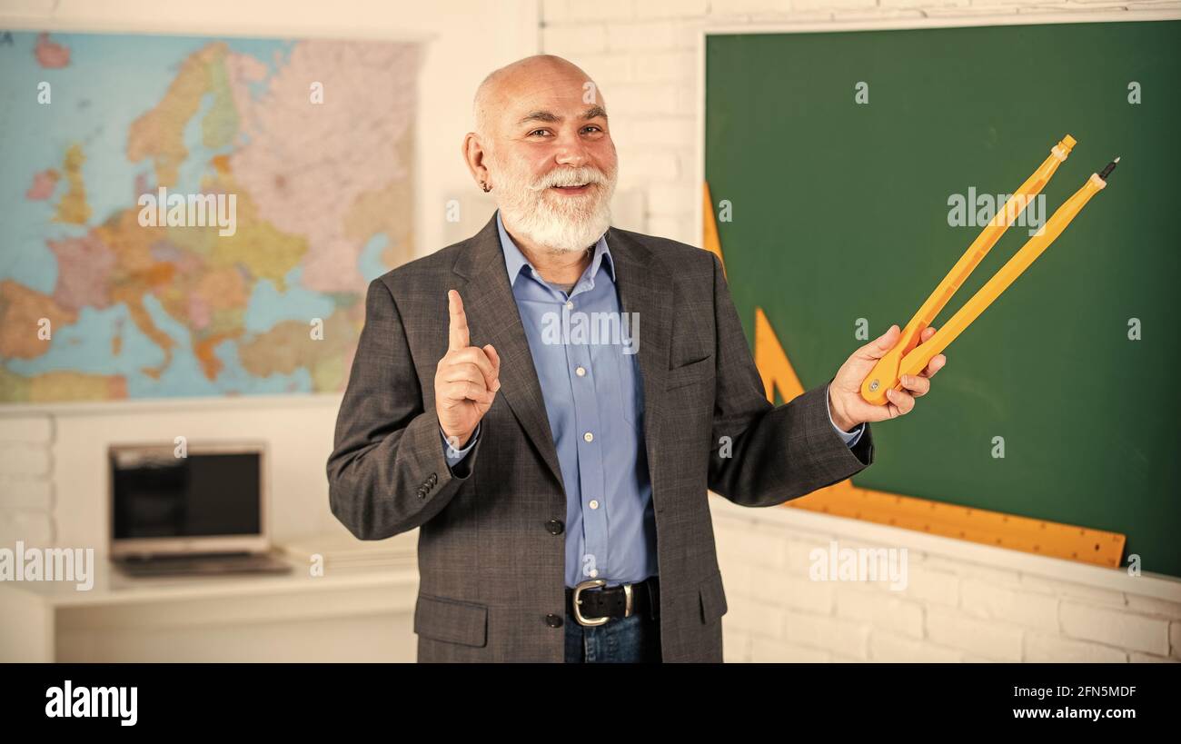 Revisione degli errori. Uomo tutor bearded disegna con bussola su lavagna. Torna a scuola. Concetto di strumenti grafici matematici. Verso la conoscenza. Studiare matematica per ottenere Foto Stock