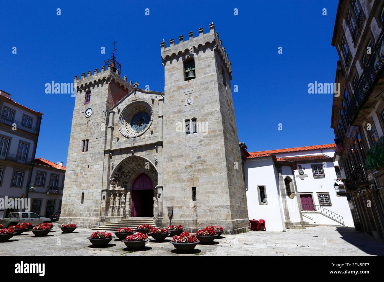 Facciata dell'ingresso principale e torri della cattedrale gotica romanica / Igreja Matriz e fiori in estate, Viana do Castelo, Portogallo settentrionale Foto Stock