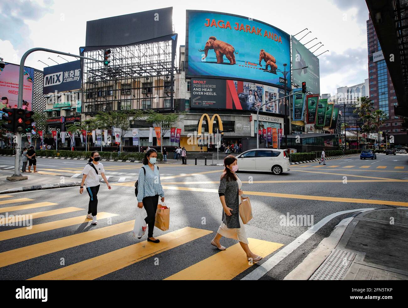 Kuala Lumpur, Malesia. 14 maggio 2021. I pedoni che indossano mascherine come precauzione contro la diffusione del coronavirus visto attraversare la giunzione durante il secondo giorno delle celebrazioni Hari Raya.il primo ministro malese Muhyiddin Yassin, ha annunciato che l'intera Malesia è posta sotto l'ordine di controllo di movimento (MCO) dal 12 maggio al 7 giugno 2021, A causa dell'aumento delle infezioni da Covid-19. Credit: SOPA Images Limited/Alamy Live News Foto Stock