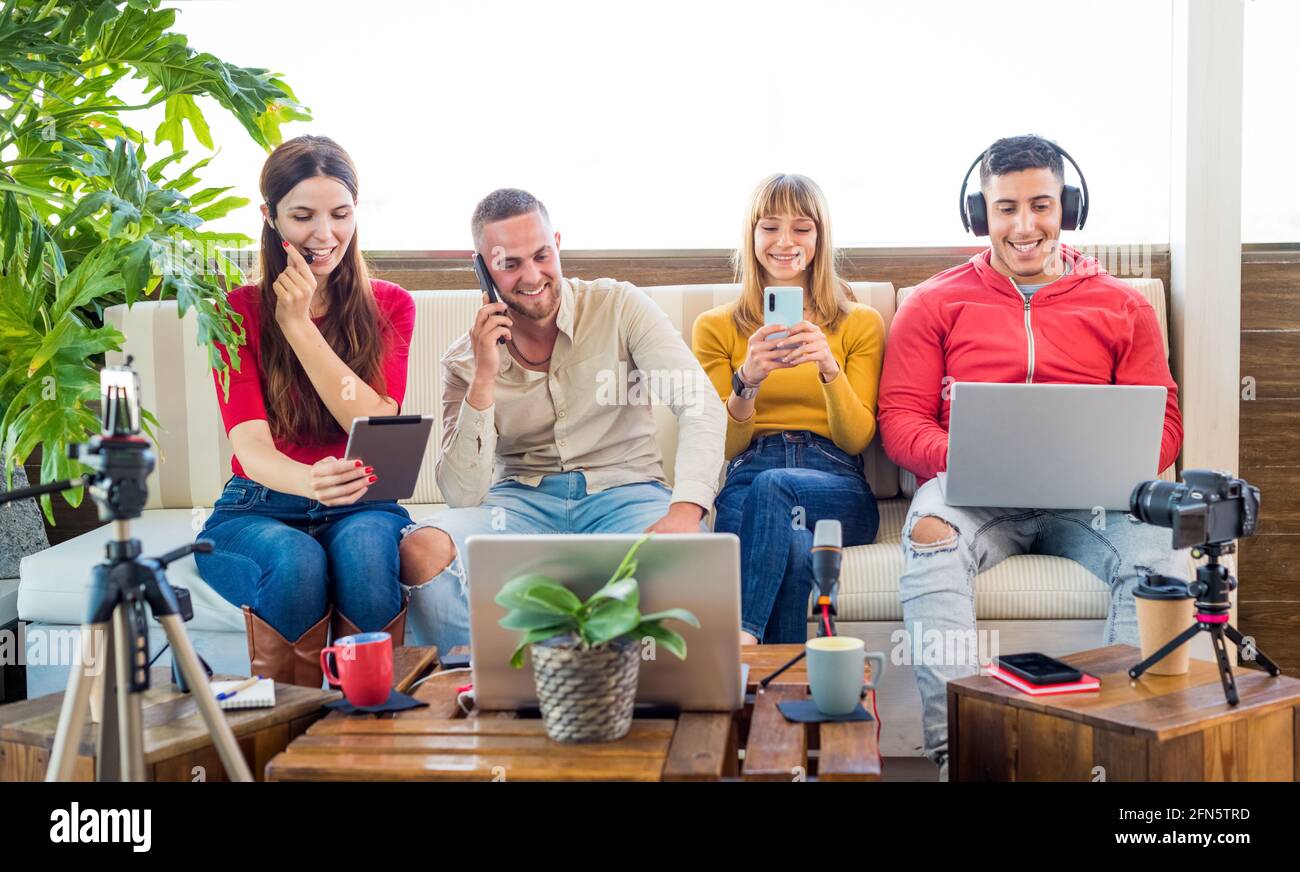 Gruppo multiculturale di amici che ignorano la comunicazione dal vivo durante la chat Nei social network o negli smartphone che utilizzano la rete wireless 5G Internet domestica Foto Stock