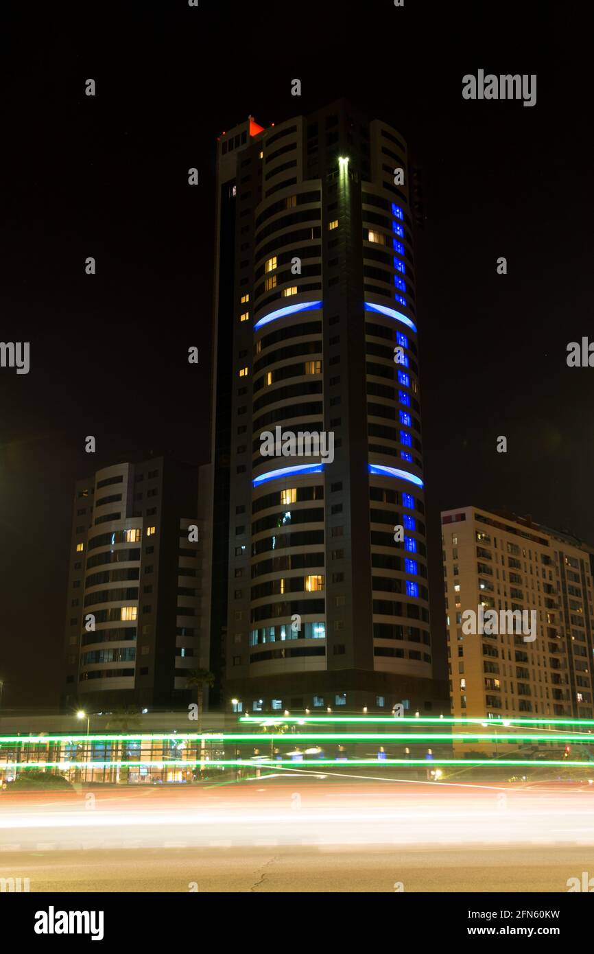 Sentieri del traffico di notte di fronte a un moderno buio edificio Foto Stock