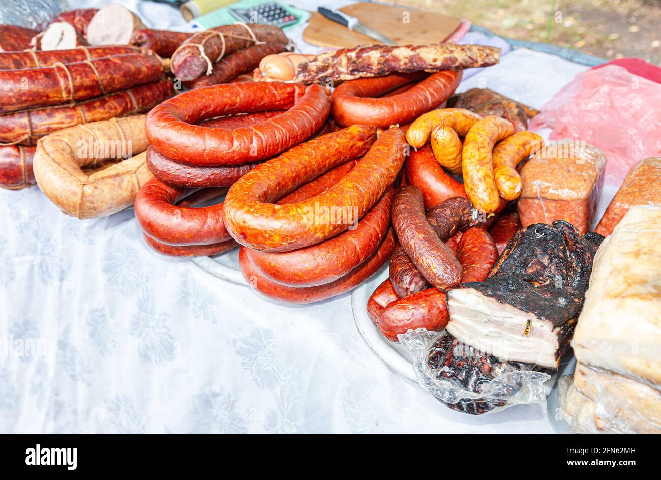 Vendita di carni affumicate fatte in casa, salsiccia e lardo al mercato agricolo Foto Stock