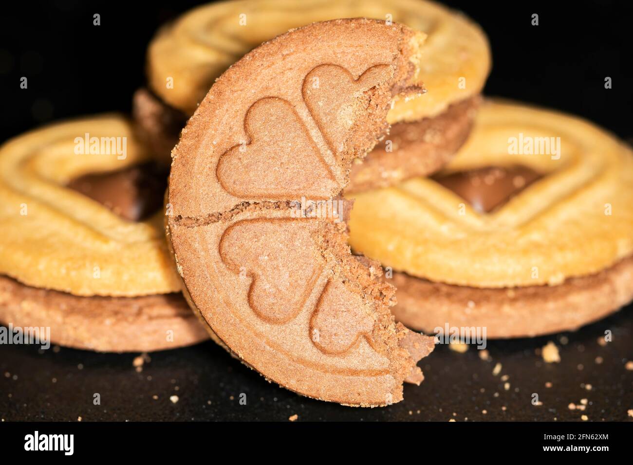 Biscotti rotondi riempiti di cioccolato con motivo a cuore, macro Foto Stock