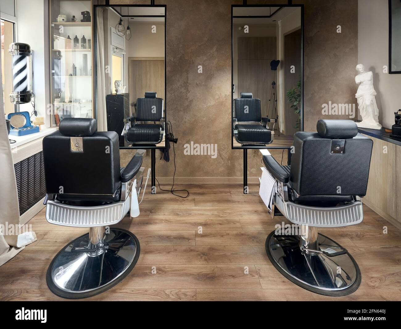 Barbiere o barbiere vintage design parrucchiere vuoto con due sedie e due specchi statua e accessori. Foto Stock