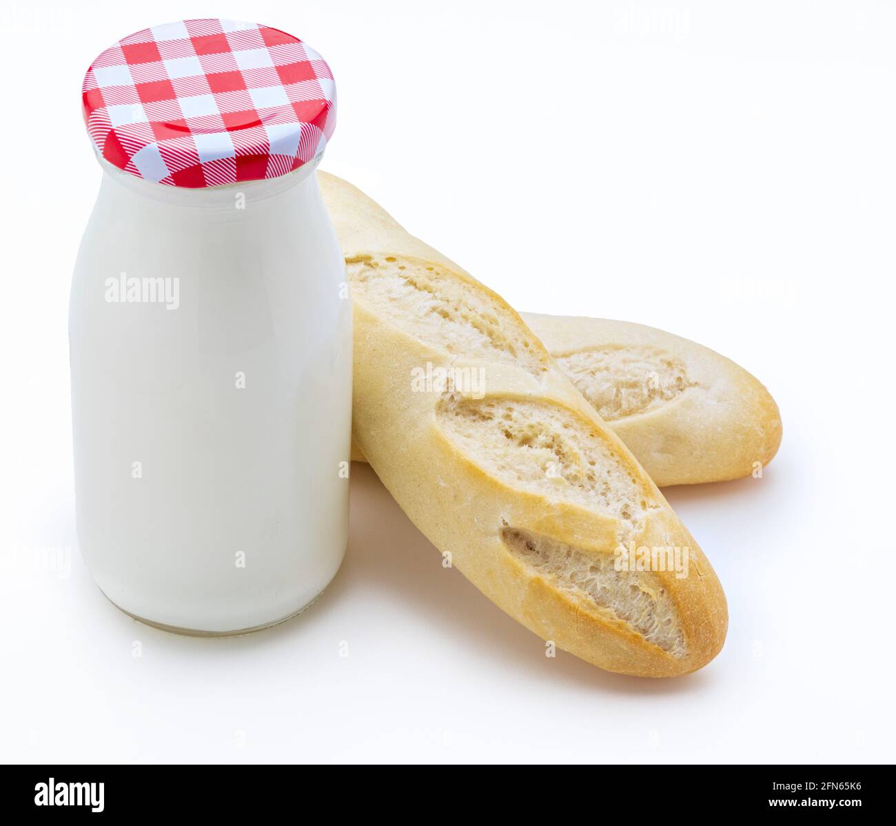 Bottiglia di latte e focacce di pane (baguette), spazio copia. Vista dall'alto. Isolato su sfondo bianco. Foto Stock