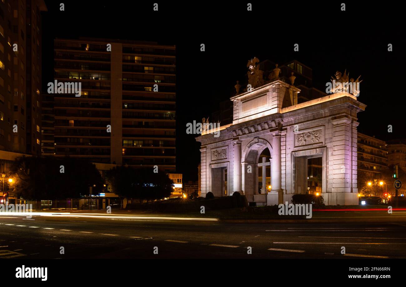 Monumento di 'Puerta del Mar' (porta del mare) nella città di Valencia, Spagna, di notte con sentieri al semaforo. Concetto di viaggio Foto Stock