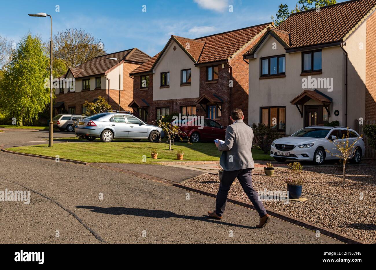 Douglas Ross, leader del partito conservatore scozzese, distribuisce 2021 volantini elettorali in una tenuta di case, Haddington, East Lothian, Scozia, Regno Unito Foto Stock