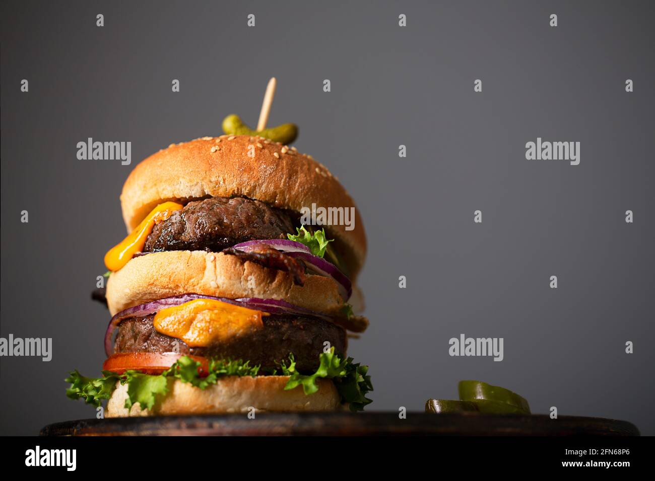Hamburger fatto in casa con due fette e formaggio fuso con cipolla e pancetta, con spazio copia Foto Stock