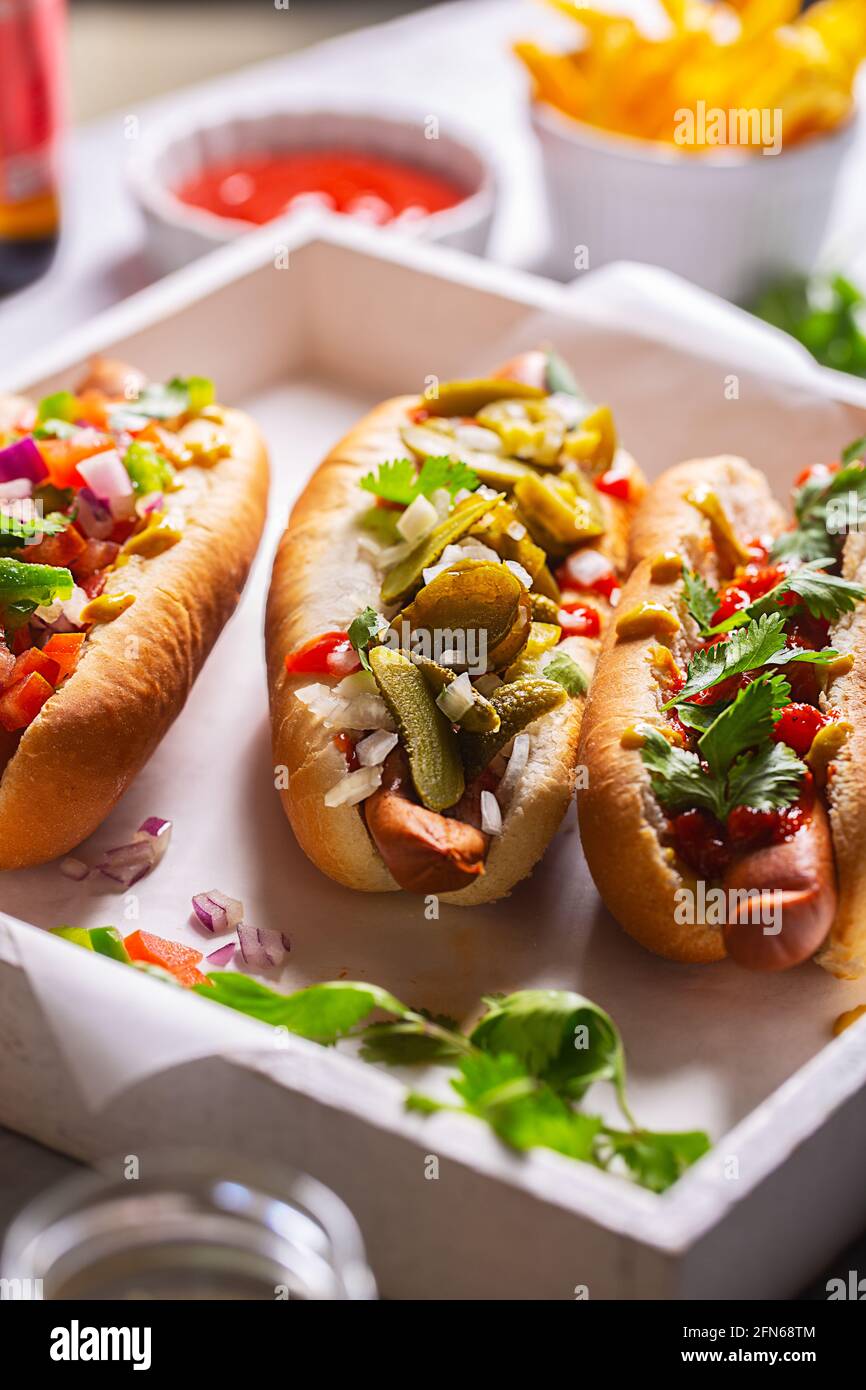 Hot dog con diversi condimenti piccanti, primo piano Foto Stock