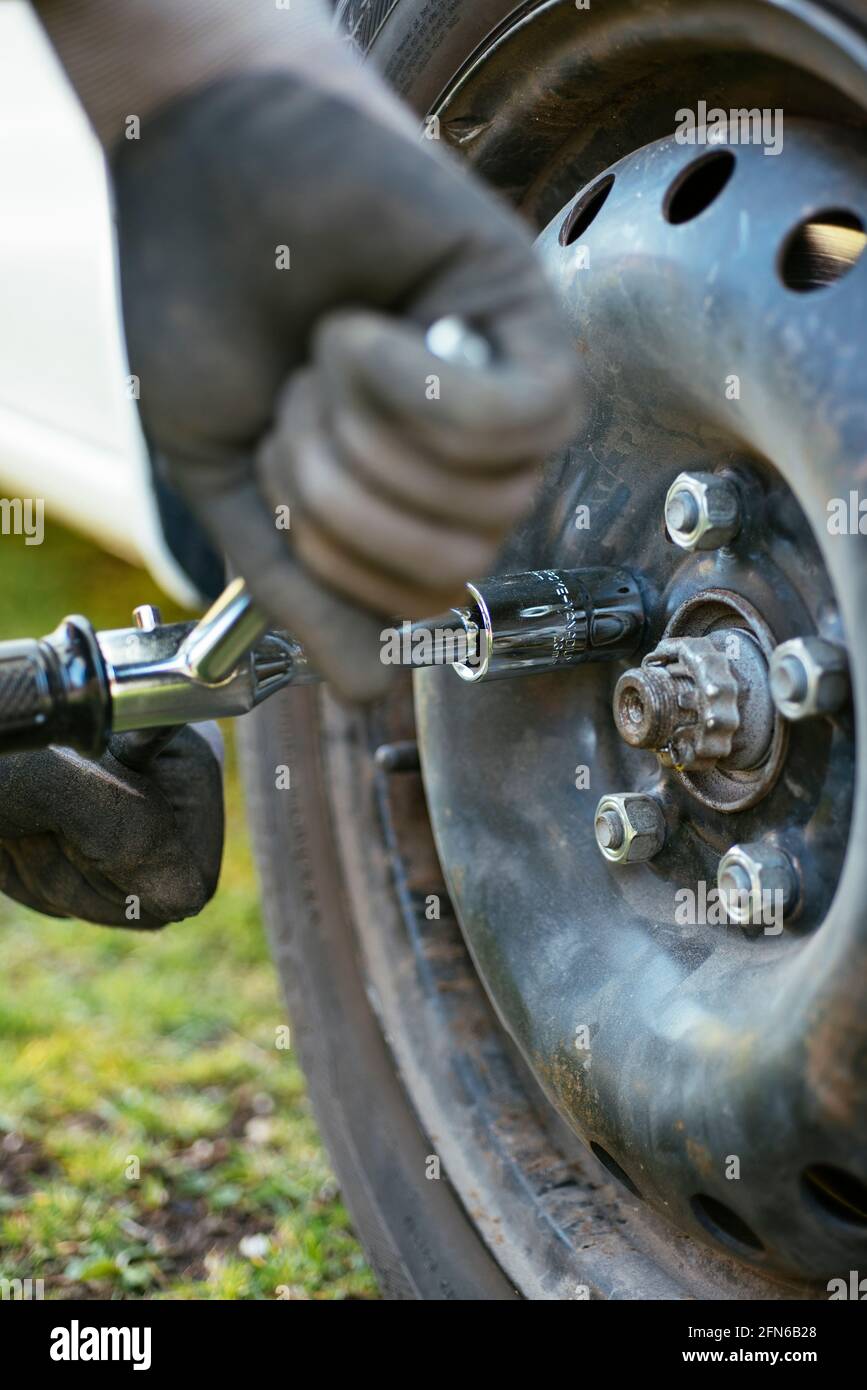 Man allentando (o serrando) un dente per non sostituire il pneumatico. Foto Stock
