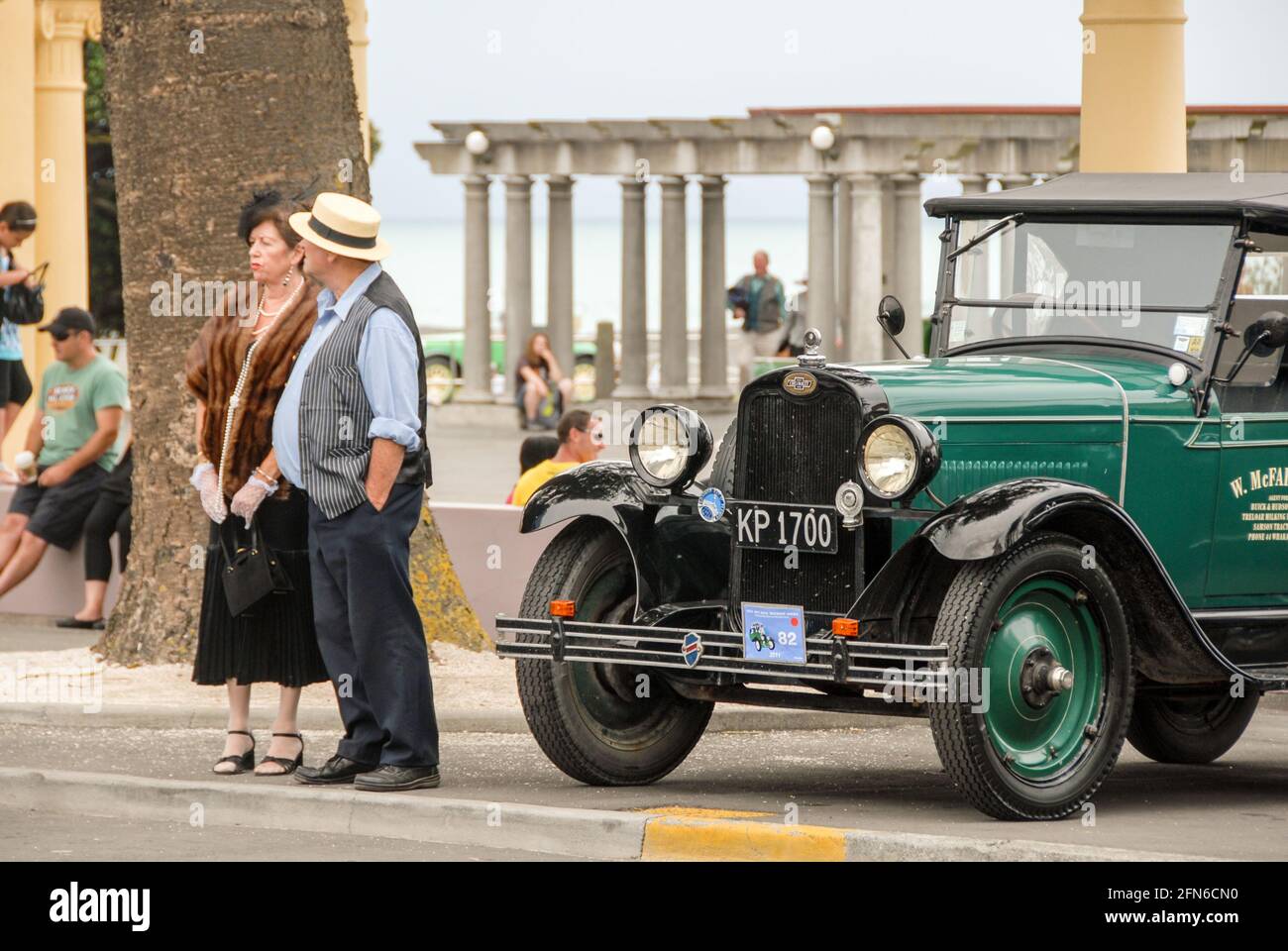 Andando in stile: Una coppia che partecipa alla celebrazione annuale durante il fine settimana Art Deco a Napier vestito in stile 30s accanto a una Chevrolet auto d'epoca. Foto Stock