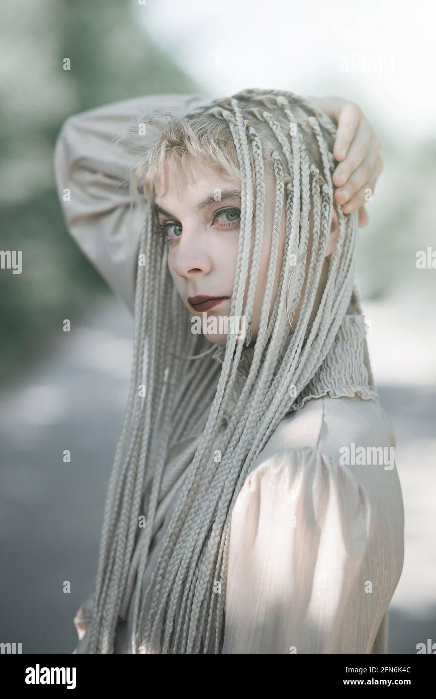 Giovane donna elegante che posa per ritratti all'esterno, bellezza e concetto di moda Foto Stock