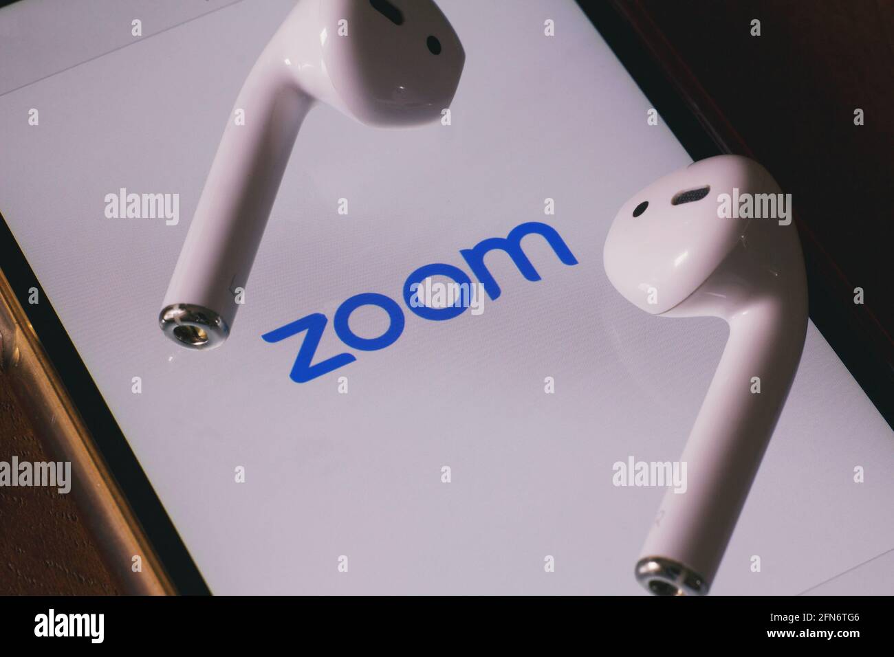 Firenze, Italia, 14 maggio 2021, primo piano di uno smartphone con l'applicazione 'zoom' aperta con auricolari wireless. Foto Stock