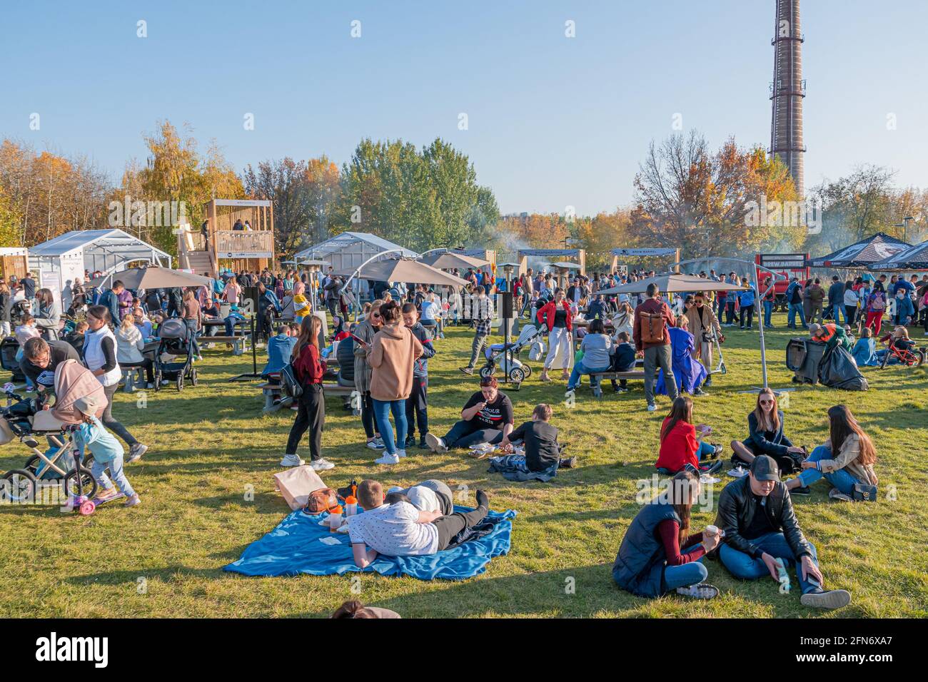 Kazan, Russia - 03 ottobre 2020: I residenti si rilassano, si siedono e si trovano sul prato nel parco cittadino, intorno al quale ci sono molti ristoranti mobili barbecue. Foto Stock