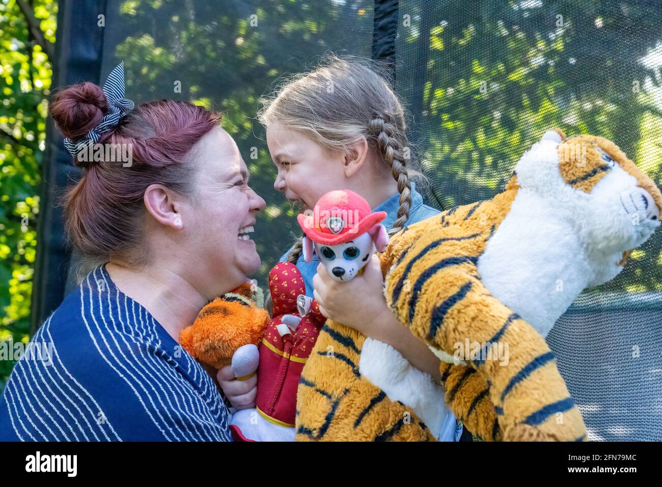 Lynwood, Washington, Stati Uniti. La ragazza di quattro anni e la madre abbracciano ed essendo affettuosa. (SIG.) Foto Stock