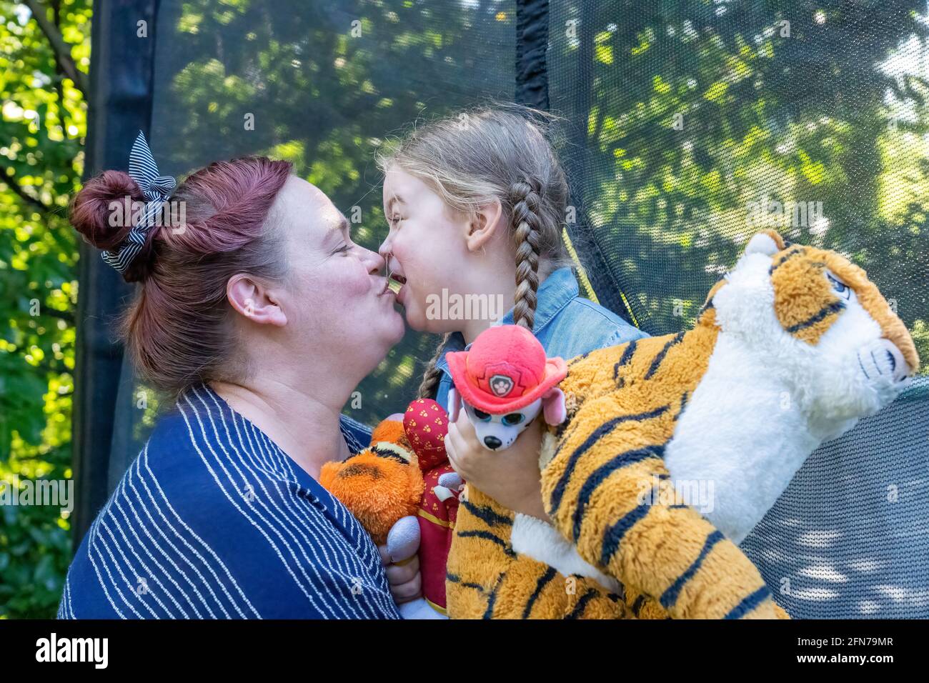 Lynwood, Washington, Stati Uniti. La ragazza di quattro anni e la madre abbracciano ed essendo affettuosa. (SIG.) Foto Stock