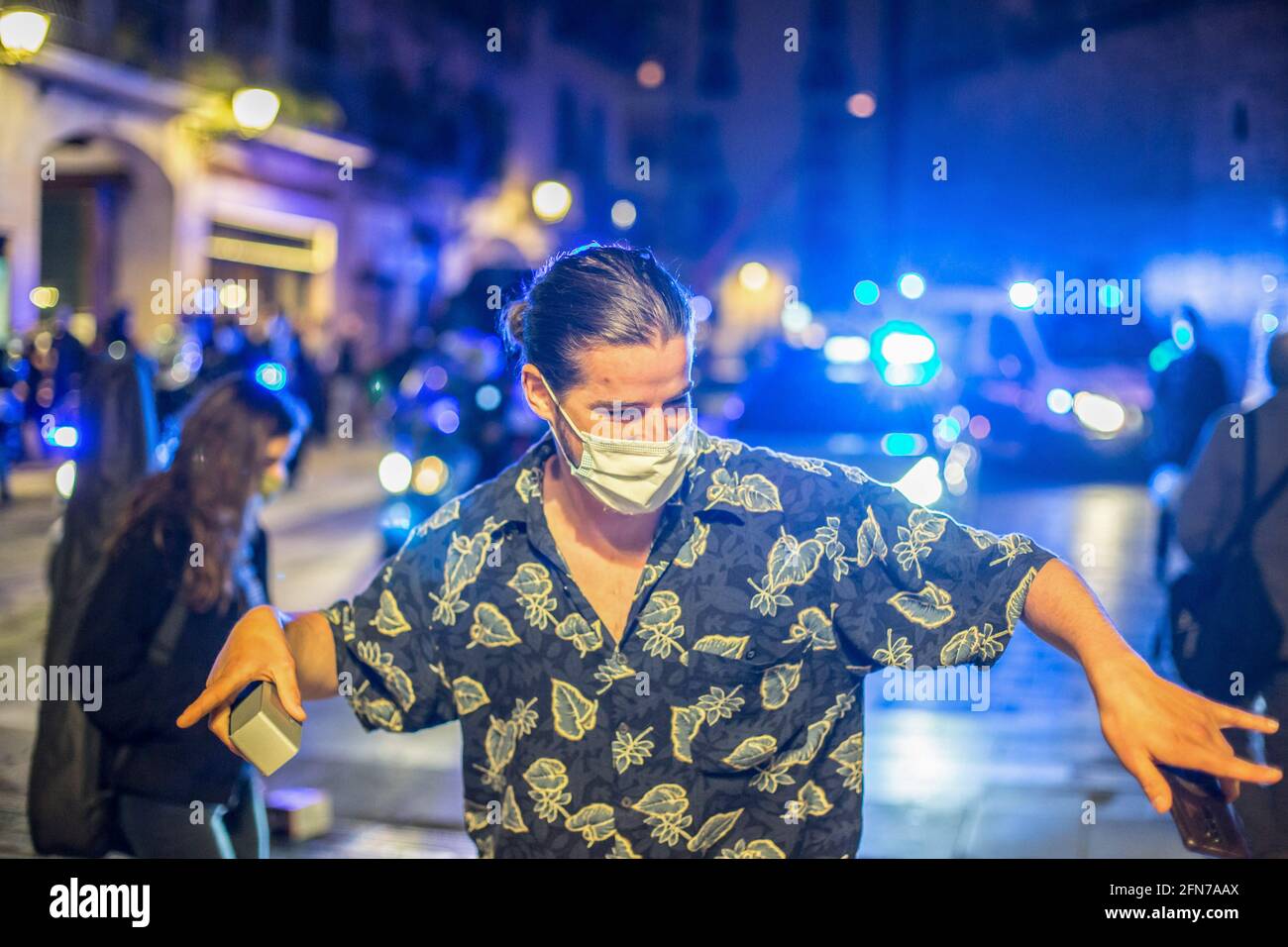 Barcellona, Spagna. 14 maggio 2021. L'uomo è visto ballare di fronte alle auto della polizia per le strade di Barcellona. Il primo fine settimana senza uno stato di allarme e senza un coprifuoco a Barcellona, le strade del centro della città sono piene di persone che si incontrano per bere senza distanza di sicurezza o maschera di protezione. La polizia ha effettuato un'operazione di sfratto. Credit: SOPA Images Limited/Alamy Live News Foto Stock
