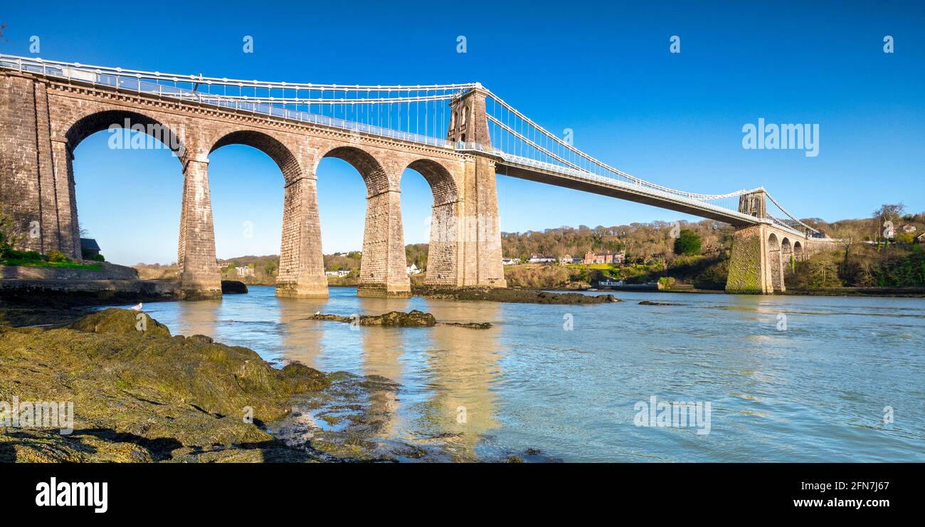 Vista panoramica del Ponte sospeso Menai, progettato da Thomas Telford e inaugurato nel 1826. Attraversa lo stretto di Menai vicino Bangor a Anglesey. Foto Stock